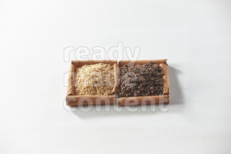 2 squares of cinnamon sticks full of cloves and sesame on white flooring