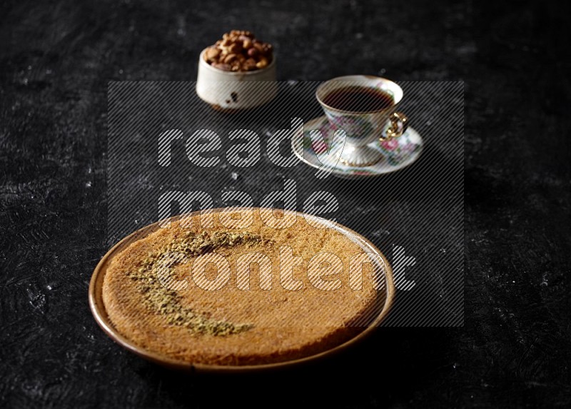 Konafa with nuts and tea in a dark setup