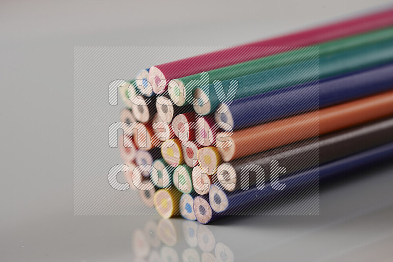 An array of colored pencils on grey background