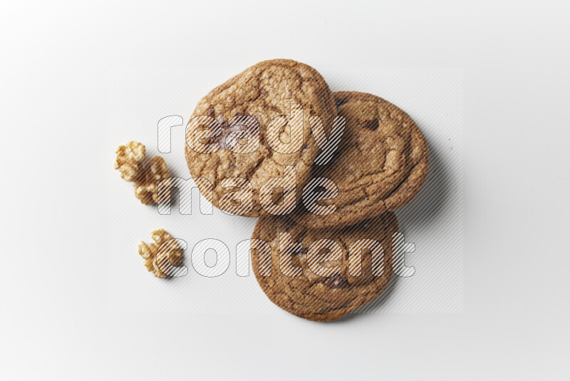 Chocolate chips cookies with walnuts beside it on a white background