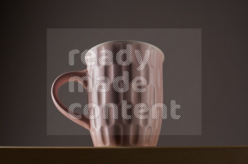 Low angle shot of a pink cup on grey background