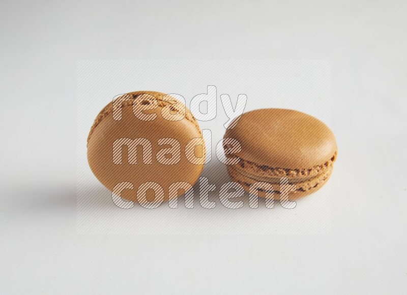 45º Shot of two Brown Maple Taffy macarons on white background