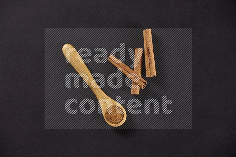 3 Cinnamon sticks stacked beside a wooden spoon full of cinnamon powder on black background in different angles