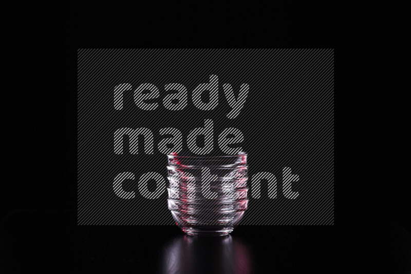 Glassware with rim light in red and white against black background