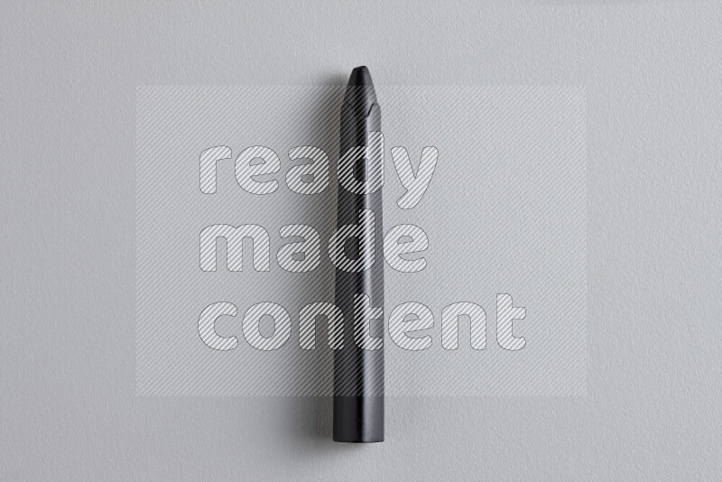 A close-up showing a single wax crayon on grey background