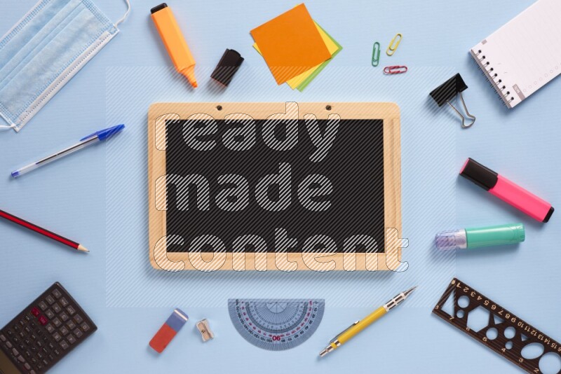 A blackboard with assorted school supplies on blue background