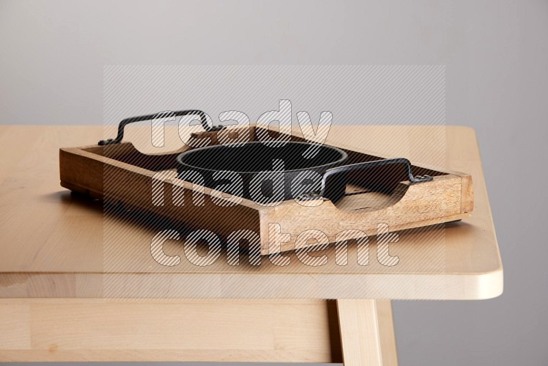 black bowl on a light colored rectangular wooden tray with handles