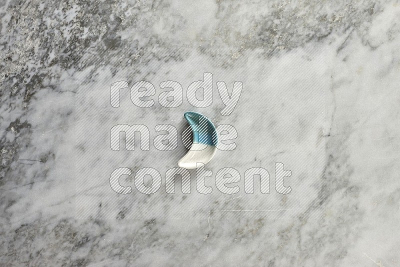 A pottery crescent plate on grey marble background