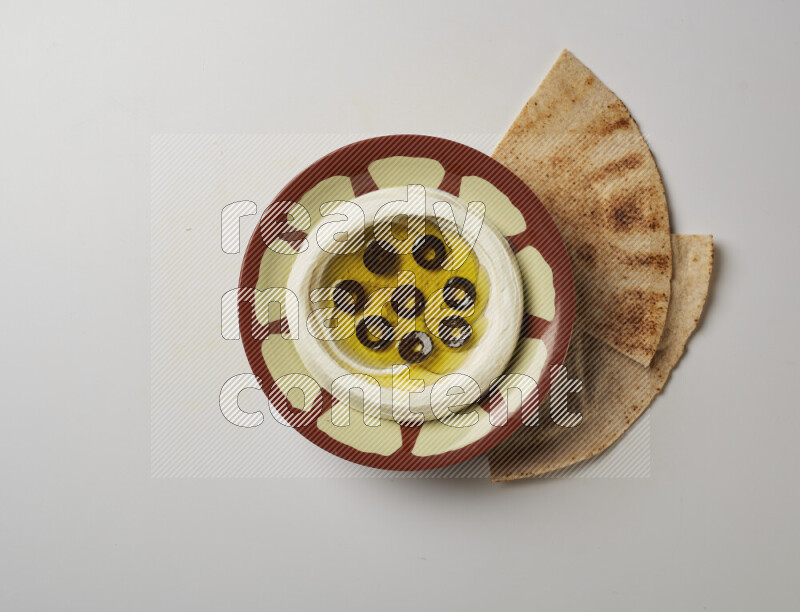 Lebnah garnished with sliced olives in a traditional plate on a white background