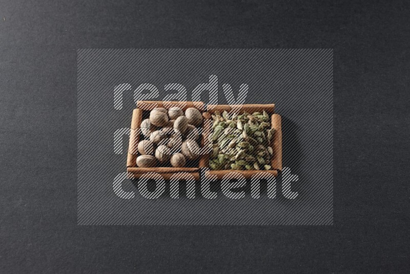 2 squares of cinnamon sticks full of nutmegs and cardamom on black flooring