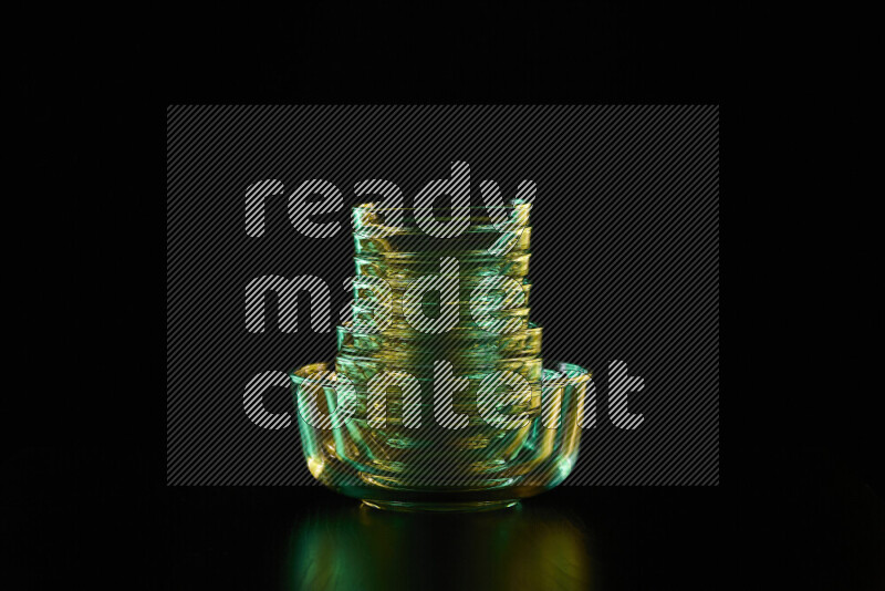 Glassware with rim light in green and yellow against black background