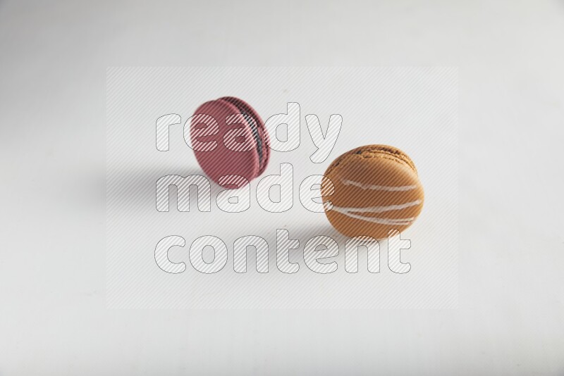 45º Shot of of two assorted Brown Irish Cream, and Red Cherry macarons on white background