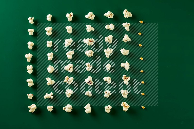 Popcorn flakes and seeds on a green background in a top view shot