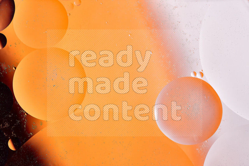Close-ups of abstract oil bubbles on water surface in shades of white and orange