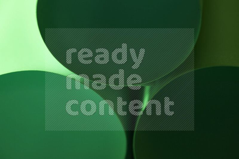 الصورة تعرض فن ورقي تجريدي بأشكال دائرية بدرجات متنوعة من اللون الأخضر