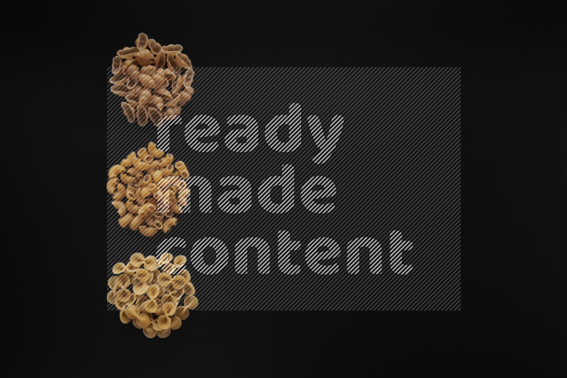 Different pasta types in 3 bunches on black background