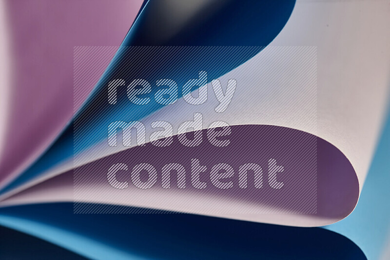 An abstract art showing purple and blue paper sheets arranged in an overlapping curves