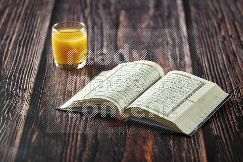 Quran with dates, prayer beads and different drinks on wooden background