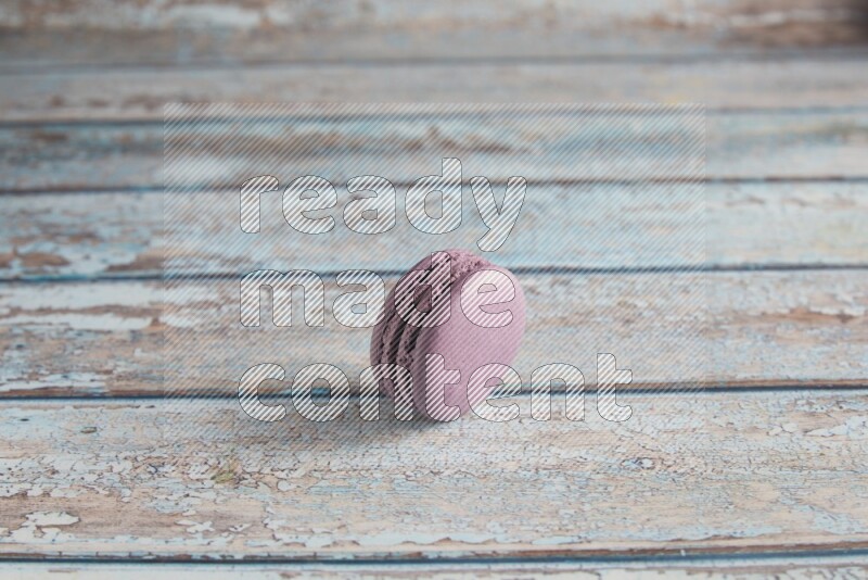 45º Shot of Purple Blueberry macaron on light blue wooden background