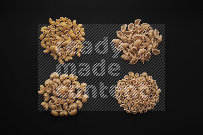 Different pasta types in bunches on black background