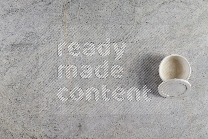 Top View Shot Of A Multicolored Pottery Cup On Grey Marble Flooring