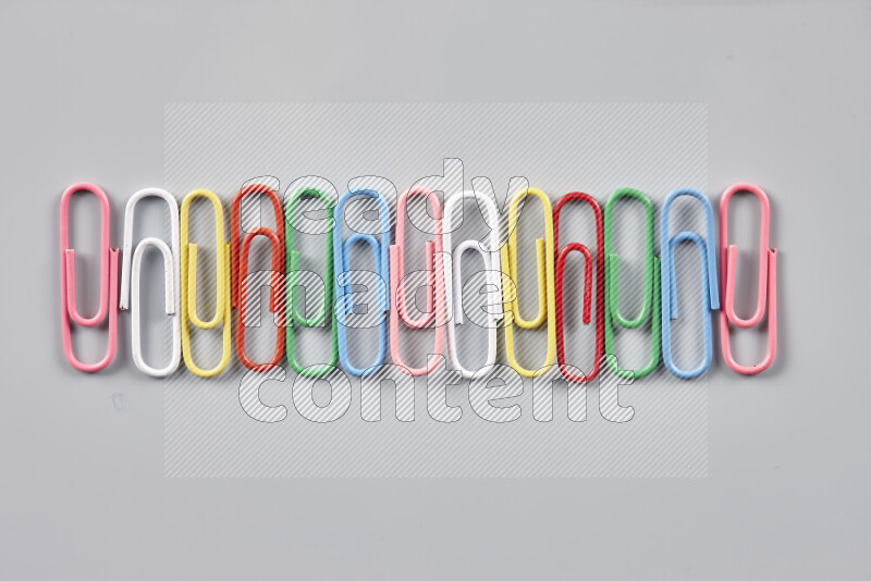 Multicolored paper clips isolated on a grey background