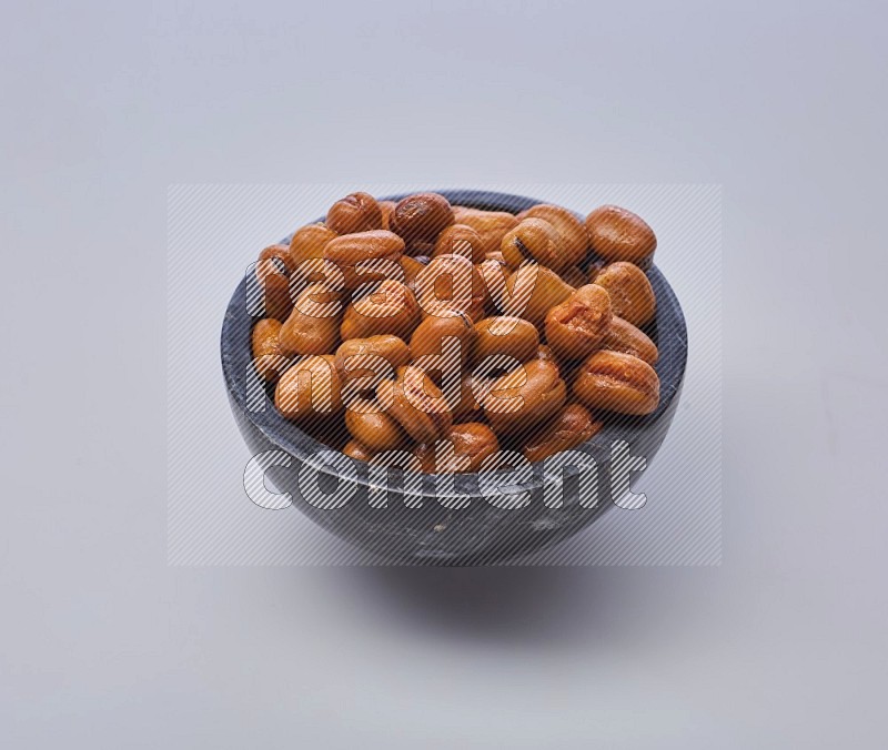 Close up shot of cooked fava beans (foul) in a container on white background