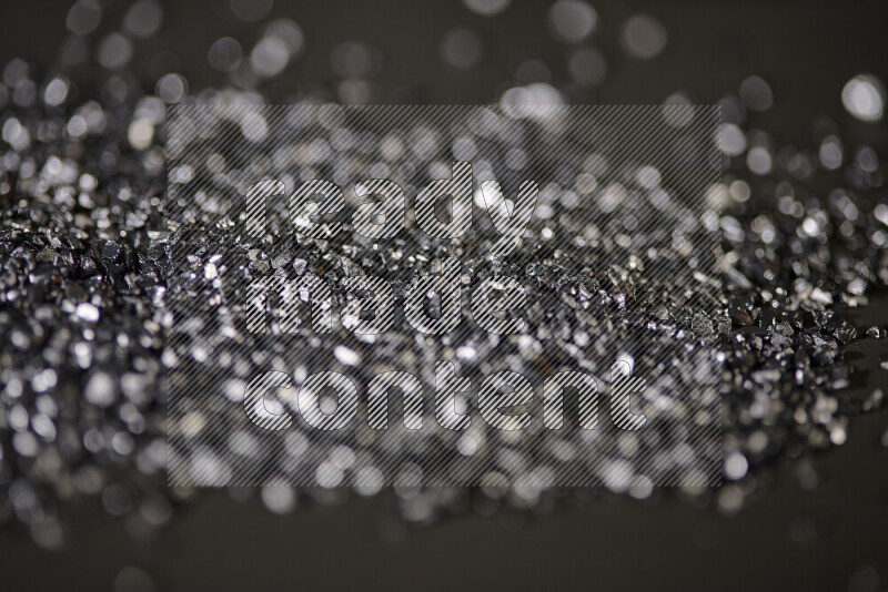 قطع زجاجية سوداء لامعة متناثرة على خلفية سوداء