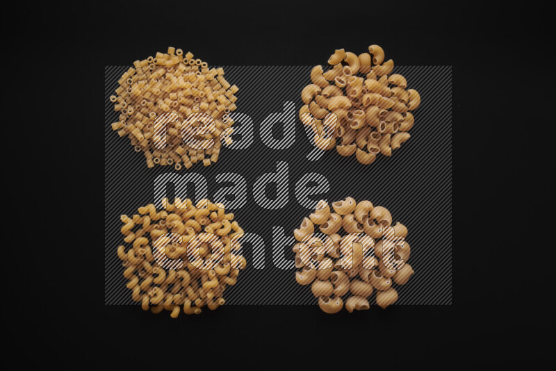 Different pasta types in bunches on black background