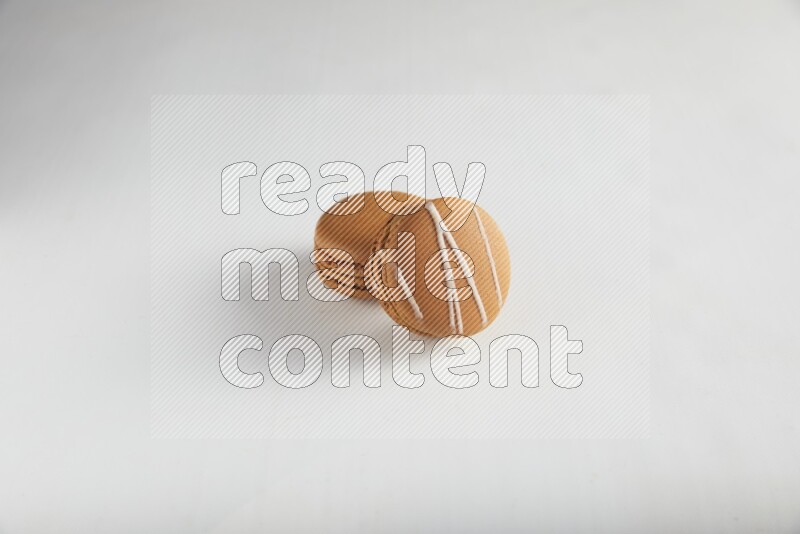 45º Shot of of two assorted Brown Irish Cream, and Brown Maple Taffy macarons  on white background