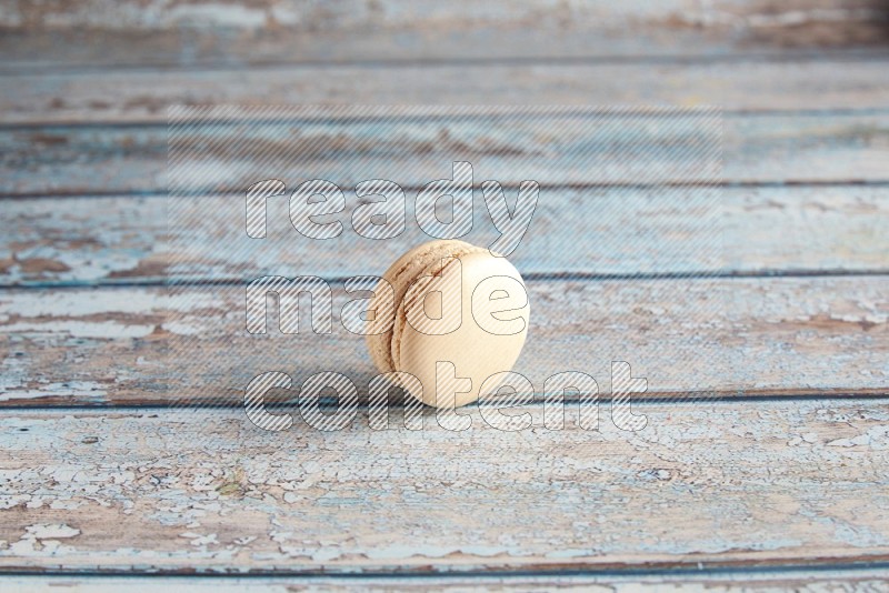 45º Shot of White Caramel fleur de sel macaron on light blue wooden background