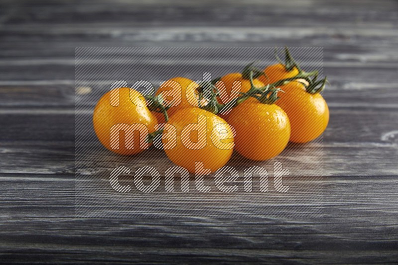 Yellow cherry tomato vein on a textured grey wooden background 45 degree