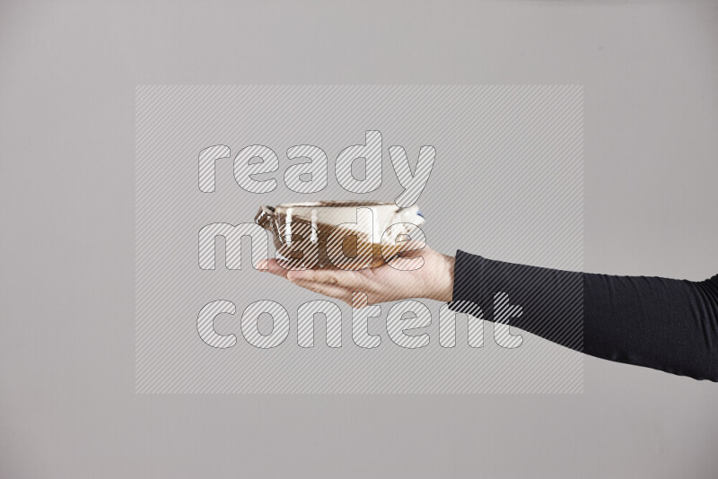 A woman in black abaya holding different pottery essentials in different positions