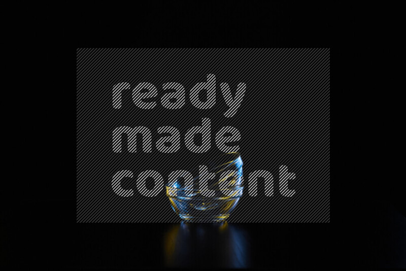 Glassware with rim light in blue and yellow against black background