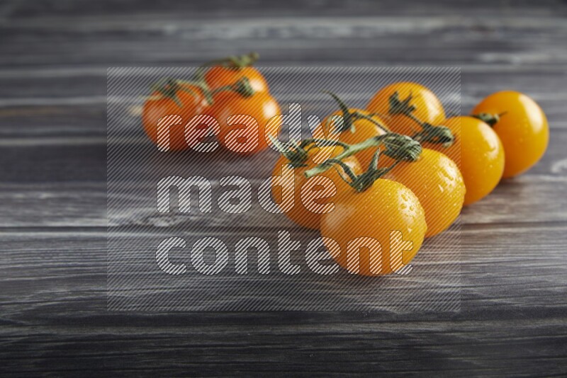 Mixed cherry tomato veins on a textured grey wooden background 45 degree