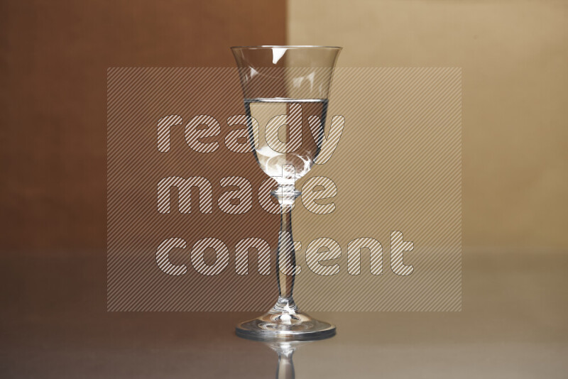 The image features a clear glassware filled with water, set against brown and light brown background