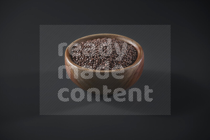 Brown lentils in a wooden bowl on grey background