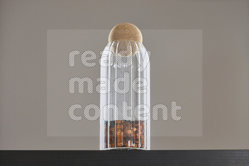 Sequins in a glass jar on black background