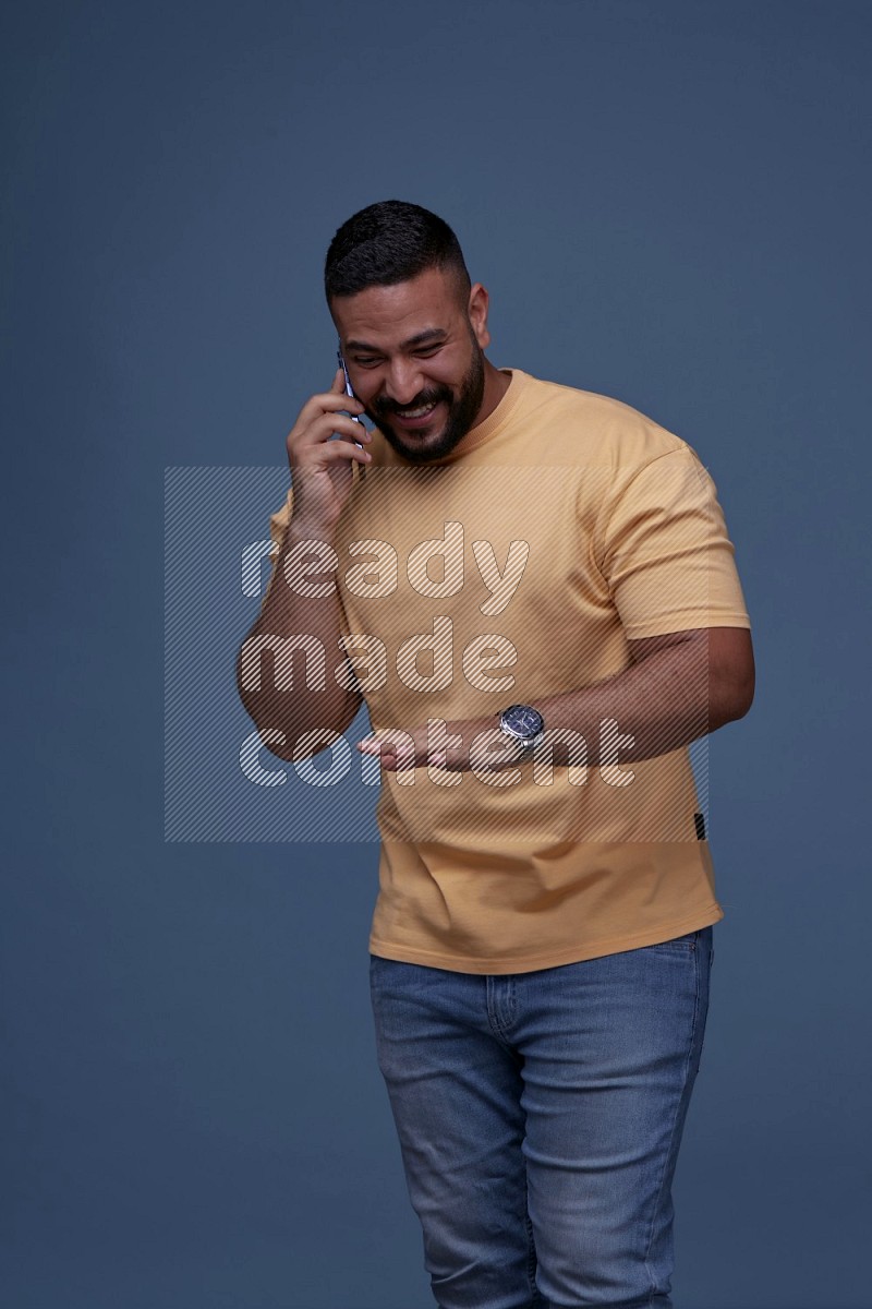 A man Calling on Blue Background wearing Orange T-shirt