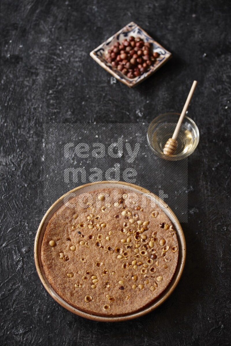 بسبوسة بالمكسرات والعسل علي خلفية سوداء خشبية