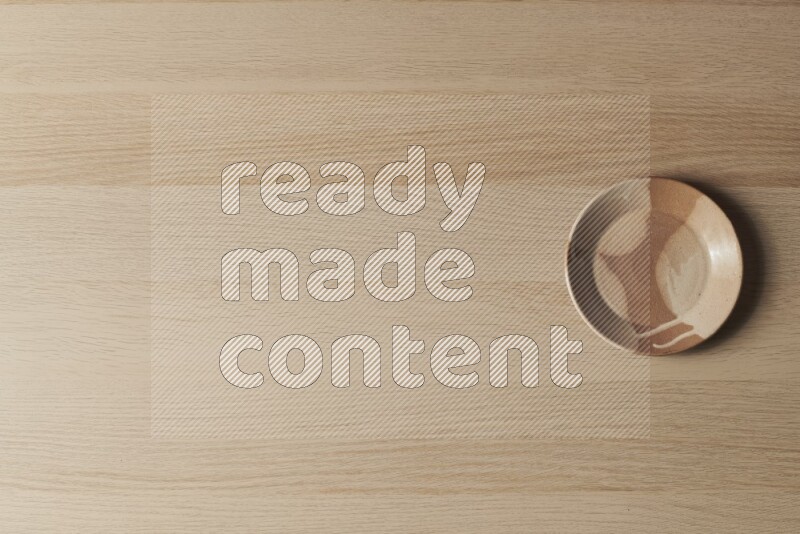 صحن فخاري متعدد الألوان على خلفية خشبية فاتحة