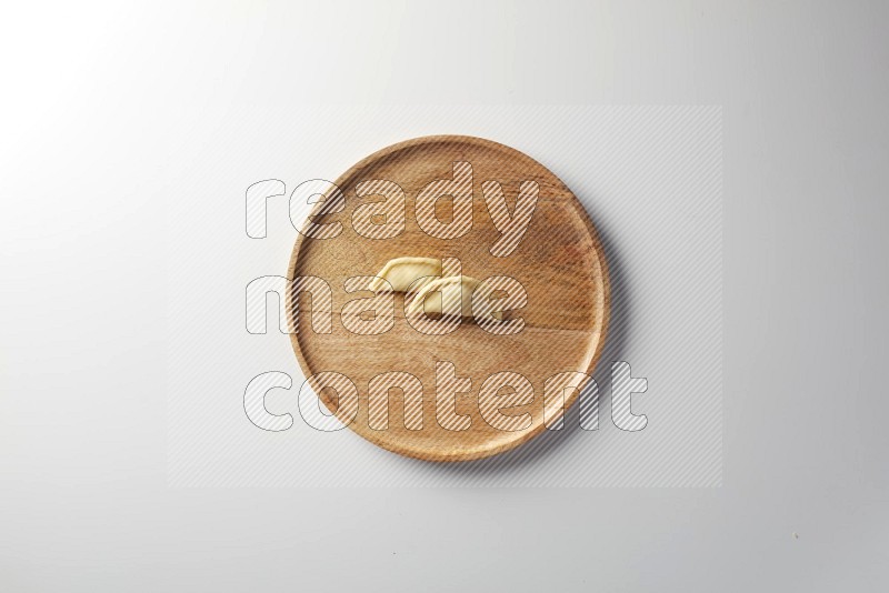 Two Sambosas on a wooden round plate on a white background