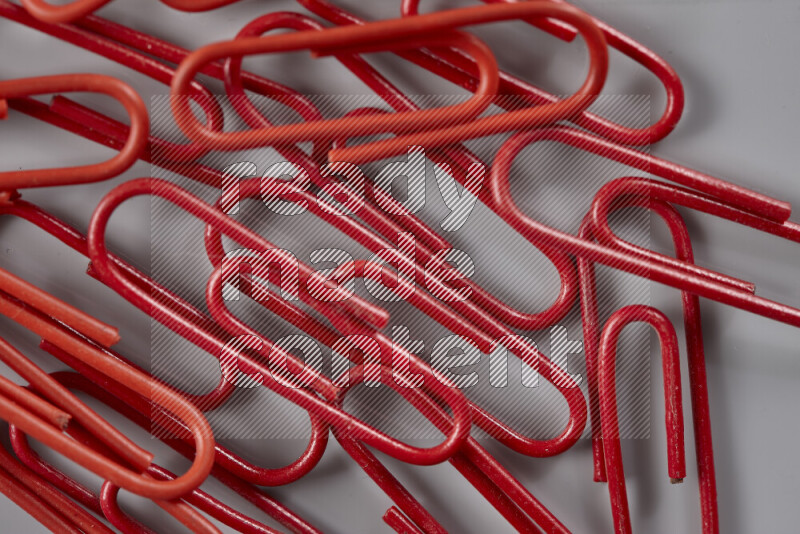 Red paper clips isolated on a grey background