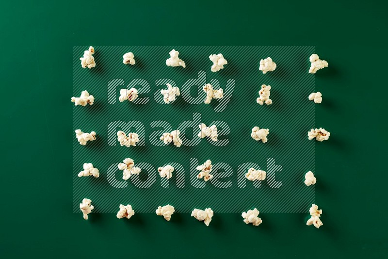 Popcorn flakes on a green background in a top view shot