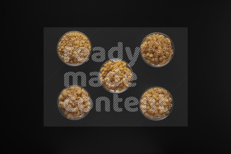 أنواع مختلفة من المعكرونة في أوعية زجاجية علي خلفية سوداء