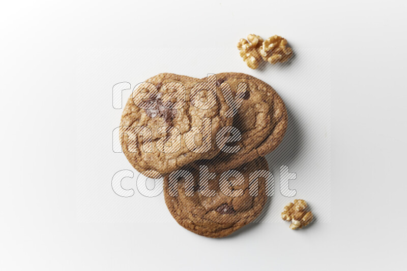 Chocolate chips cookies with walnuts beside it on a white background