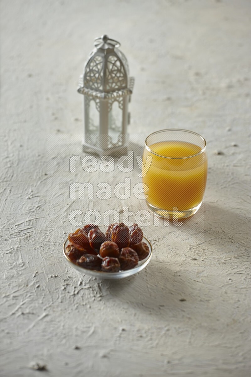 A white lantern with different drinks, dates, nuts, prayer beads and quran on white background