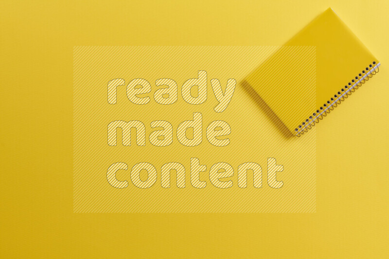 دفتر أصفر مع مستلزمات مدرسية مختلفة على خلفية صفراء