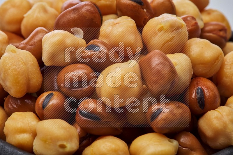 Close up shot of cooked fava beans (foul) & chickpeas on white background