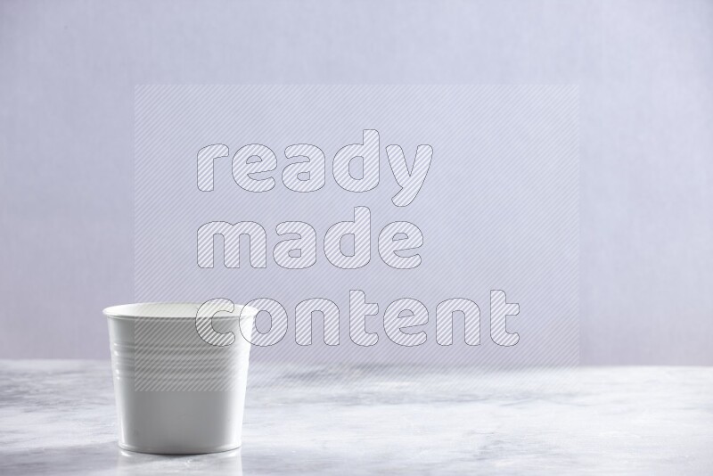 An empty white plant pot on grey marble background
